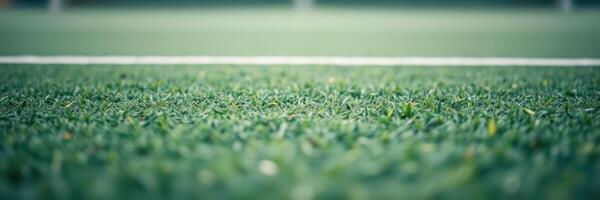 Lush green artificial turf close-up on a sports field under clear sky photo