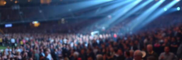 Large crowd enjoying a live concert at an indoor arena with dramatic lighting effects photo
