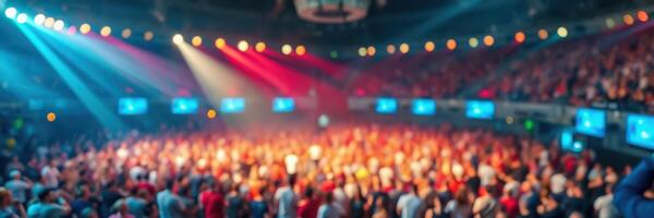 Crowd enjoying a vibrant concert with colorful lights in an indoor arena during the evening photo