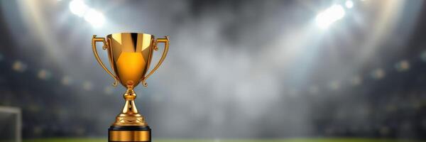 Golden trophy displayed on a blurred sports field with bright lights shining in the background during a competitive event photo