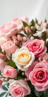 Beautiful arrangement of pink and yellow roses in a soft background featuring delicate buds and greenery photo