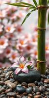 Peaceful bamboo and flower arrangement with pebbles in a serene garden setting photo