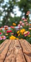 Colorful flowers bloom in a vibrant garden with a rustic wooden table in focus on a sunny day photo
