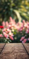 Wooden table with blurred blooming flowers in a vibrant garden during daylight hours photo