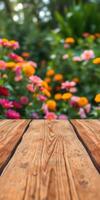 Colorful flowers bloom in a garden with a wooden table foreground during a sunny day in springtime photo