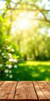 Sunlight filters through trees in a serene park filled with blooming flowers and a wooden table in the foreground photo