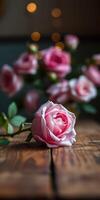 Beautiful pink roses on wooden table surrounded by blurred blooms in the background during soft evening light photo