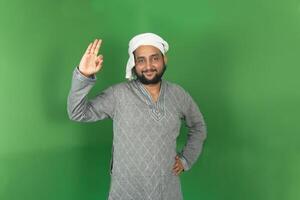 Young Indian farmer okay symbol right hand side with smiling and looking at camera, isolated on green background, green screen, copy space photo
