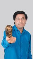 Portrait view of a young man offering to eat a corn cob with styles. photo