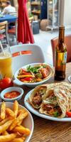 Delicious spread of tacos, fries, and vibrant salad at a lively restaurant during lunchtime photo