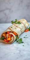 Delicious wrap filled with fresh vegetables and herbs on a marble countertop photo