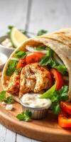 Delicious wrap filled with seasoned chicken, fresh vegetables, and creamy sauce photo