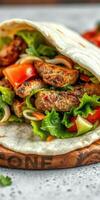 Freshly made wrap filled with grilled meat and vibrant vegetables served on a wooden platter photo