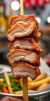 Juicy grilled pork skewers served with fresh vegetables and fries at a bustling street food market photo