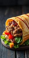 Delicious wrap filled with seasoned meat, fresh vegetables, and flavorful sauces on a dark wooden table photo