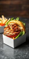 Grilled chicken sandwich served with fresh lettuce and tomato in a contemporary setting photo