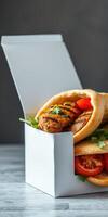Grilled chicken pita with fresh tomatoes and herbs served in a white takeout box for a delicious meal photo