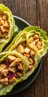 Fresh chicken lettuce wraps with crispy ingredients served on a dark wooden table for a healthy meal option photo
