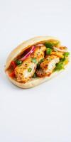 Grilled chicken wrap filled with fresh vegetables served on a white background photo