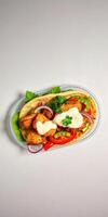 Delicious grilled chicken wrap with fresh vegetables and creamy sauce on a light background photo