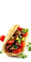 Delicious flatbread stuffed with grilled meat, fresh vegetables, and herbs on a white background photo