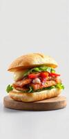 Delicious grilled chicken sandwich with fresh vegetables and sauce on a wooden board photo