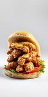 Delicious fried chicken sandwich loaded with crispy pieces and creamy sauce served on a soft bun photo