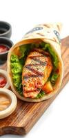 Grilled salmon wrap with fresh lettuce and assorted dipping sauces served on a wooden platter photo