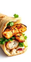Grilled chicken wrap with fresh vegetables and herbs served on a white background photo