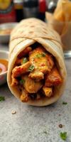 Delicious wrap filled with spicy grilled chicken and fresh herbs served on a rustic table photo