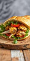 Mouthwatering chicken sandwich with cheese, fresh vegetables, and crispy lettuce served on a wooden board photo
