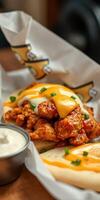 Delicious fried chicken topped with cheese and sauce served in a soft tortilla with ranch on the side photo