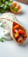 Delicious wrap filled with savory chicken, fresh vegetables, and creamy sauce served on a white plate photo