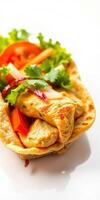 Savory chicken wrap with fresh vegetables and herbs served on a white plate photo