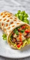 Freshly made wrap filled with chicken, vegetables, and sauce served on a plate photo