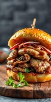 Juicy sandwich stacked high with grilled meats and fresh toppings on a rustic wooden board photo