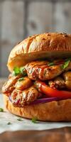 Juicy grilled chicken sandwich with fresh vegetables and herbs served on a toasted bun photo