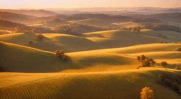 Aerial of rolling hills with a gradient of warm fall tones under a golden sky. video