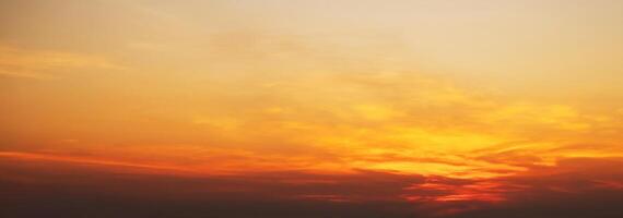 Panorama with orange sunset in cloudy sky with clouds. Background with sky at sunrise photo