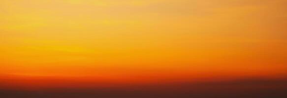 Panorama with orange sunset in cloudy sky with clouds. Background with sky at sunrise photo