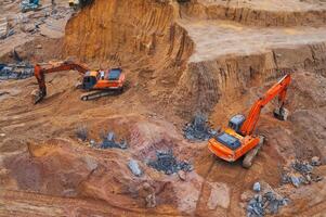 Excavators dig the ground in the foundation pit of building on a construction site. View from above photo