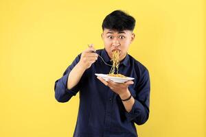 Young Indonesian Boy Wide Eyes Open, Wos Gesture While Eating Indomie Mie Goreng on White Plate photo