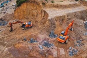 Excavators dig ground in foundation pit of building on a construction site. View from above photo