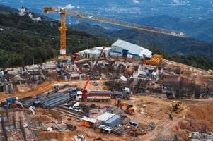 A construction site with a crane and an excavator. Development of a foundation pit for building under construction. View from above photo