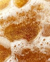 Close up of sparkling golden honey with bubbles photo