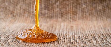 Dripping honey on textured surface photo