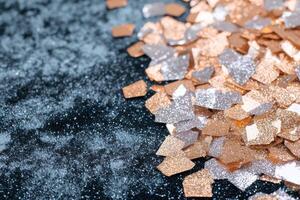 Sparkling golden and silver glitter on a dark background photo