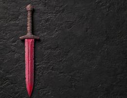 Rusty medieval sword on dark background photo