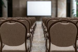 empty auditorium with rows of chairs and projection screen photo