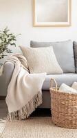 Wicker basket with throw rugs and cushions, cozy and functional living room decor. Wicker basket near grey sofa in living room photo